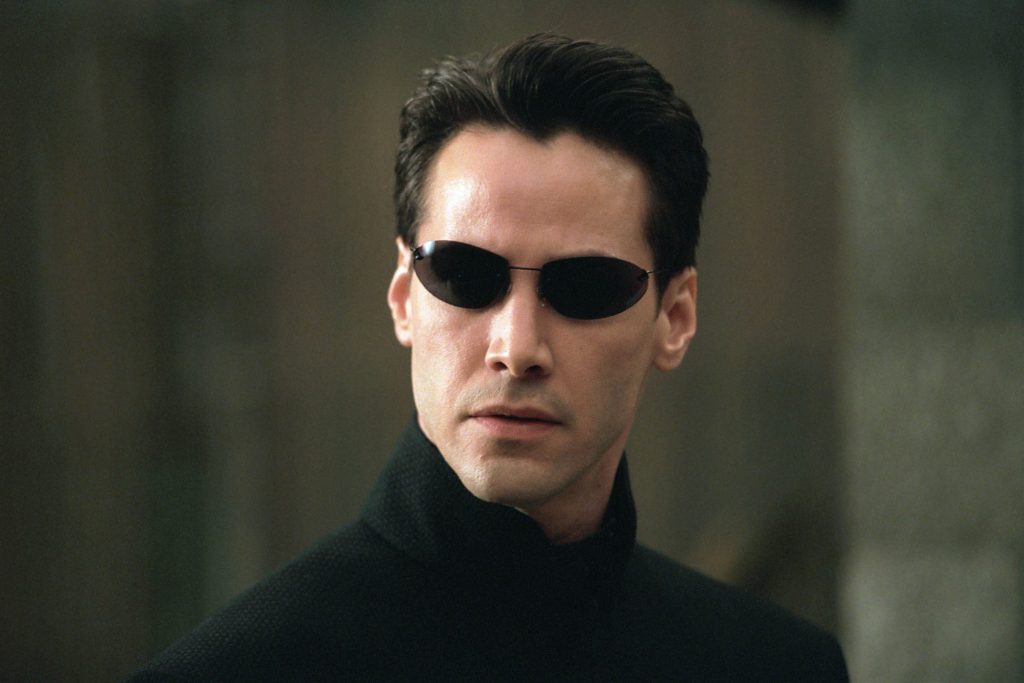 Keanu Reeves as Neo, wearing his iconic sunglasses in The Matrix Reloaded