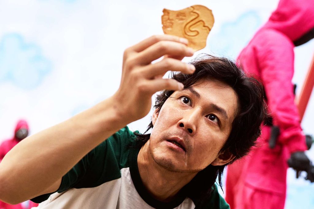 Lee Jung-jae's Seong Gi-hun holding dalgona in Squid Game 