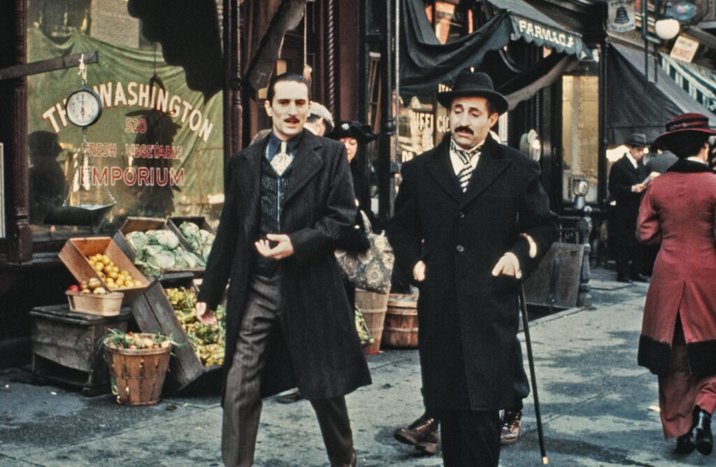 Robert De Niro as Vito Corleone and Leopoldo Trieste as Signor Roberto in The Godfather Part II