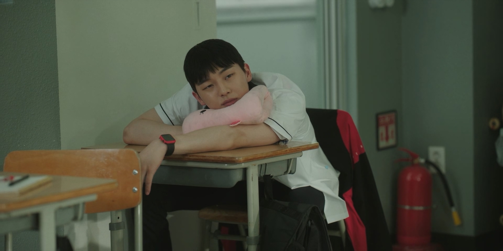 Weak Hero Class 1 still with a character sitting on his desk